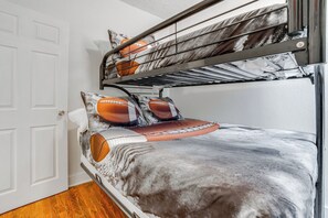 A bunk bed with a football-themed bedding and a metal ladder. - Niles Vacation Rental Near St Joseph River! (Niles)