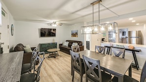 Una cocina moderna con comedor, ventilador de techo y barra.