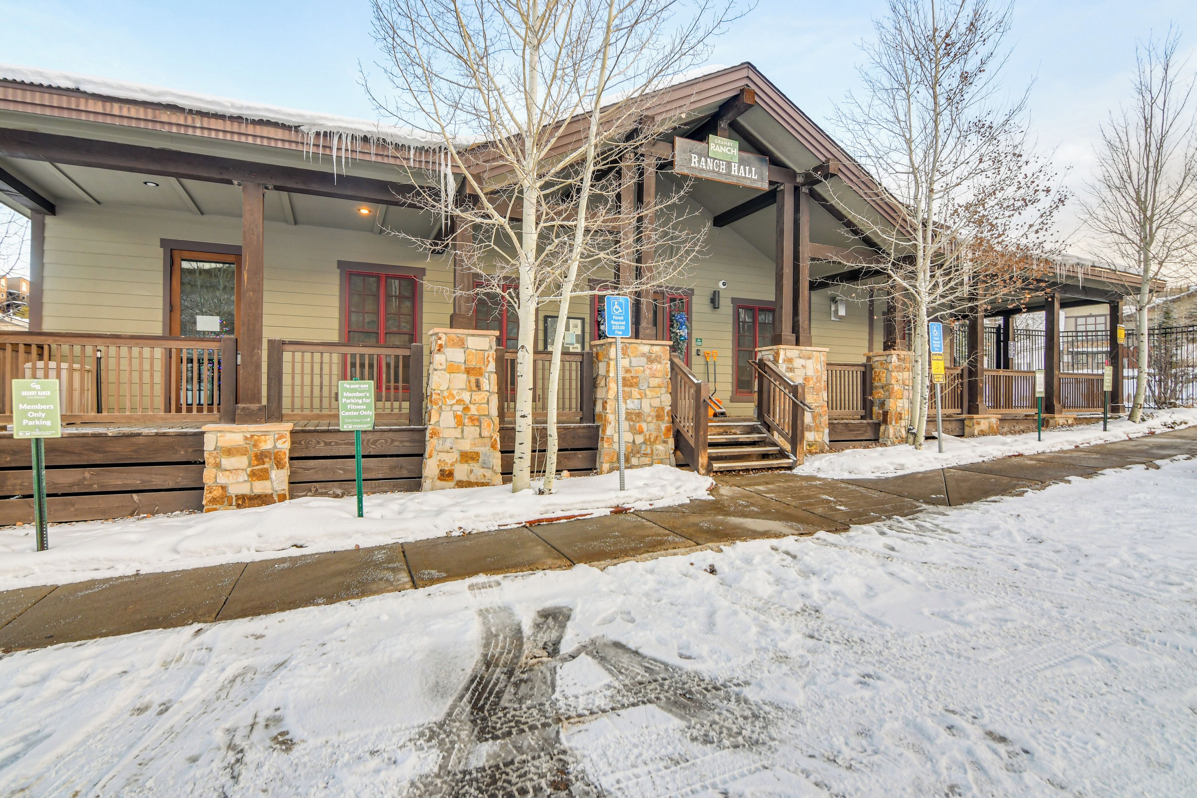 A building with a covered porch, stone pillars, and a sign for 'Ranch Hall'.