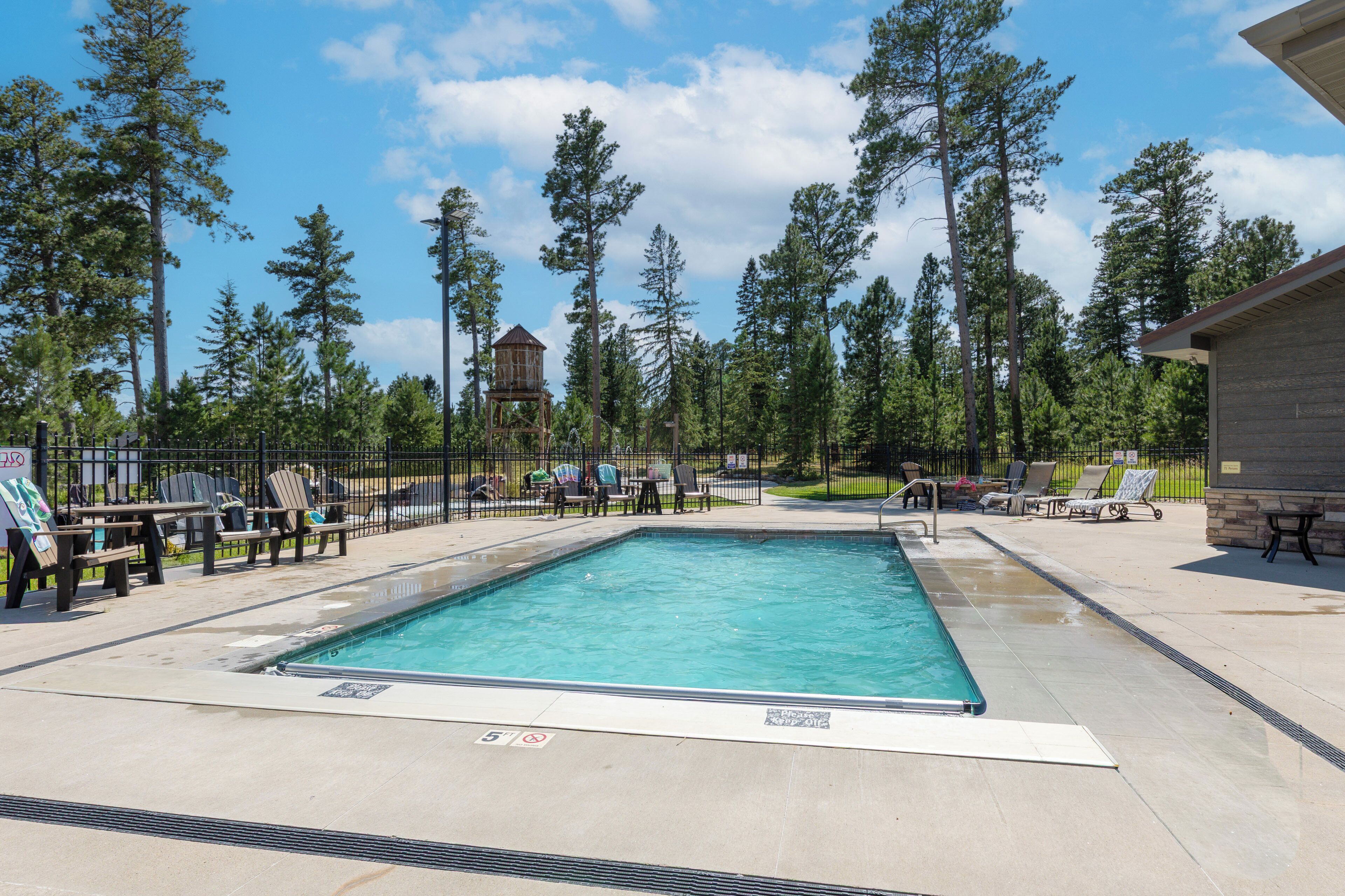 A rectangular swimming pool with a safety sign indicating a depth of 5 feet.