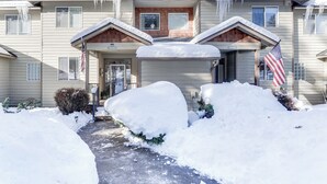 A two-story building with a covered front porch and a snow-covered driveway. - Klamath Falls Townhome w/ Deck & Resort Amenities! (Klamath Falls)