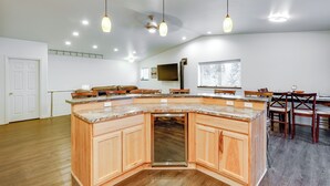 A spacious kitchen with a large island, wooden cabinets, and pendant lighting. - Family-friendly Fairbanks Home: Chena River Access (Fairbanks)