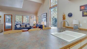 A spacious kitchen with a large island, a built-in sink, and a dining area with a table and chairs.