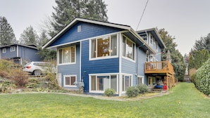 A two-story house with a balcony, a front yard, and a neighboring vehicle. - Walk to Beach & Lake Access: Cozy Redmond Apt! (Redmond)