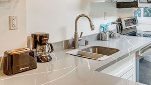 A modern kitchen with a stainless steel sink, a toaster, a coffee maker, and a microwave. - Walk to Beach & Lake Access: Cozy Redmond Apt! (Redmond)