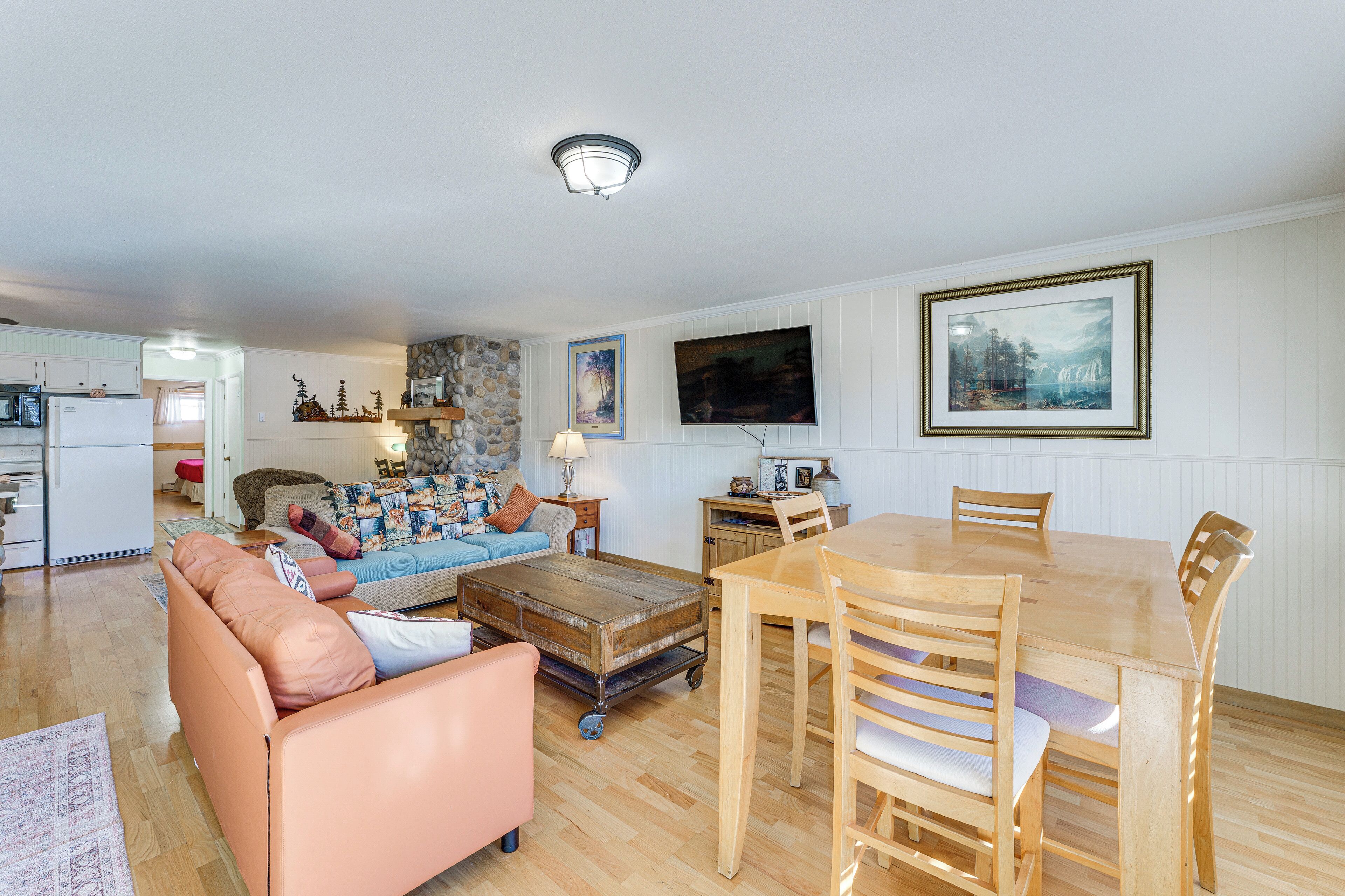 A spacious living area with a wooden dining table, a sofa, and a coffee table.