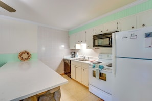A kitchen with white cabinets, a built-in oven, a microwave, and a refrigerator. - Main Street Red River Condo w/ Fireplace & Views! (Red River)
