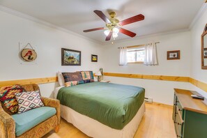 A bedroom with a bed, a chair, a ceiling fan, and a window with curtains. - Main Street Red River Condo w/ Fireplace & Views! (Red River)