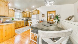 A kitchen with wooden cabinets, a dining table, and chairs. - Ruidoso Cabin Rental w/ Hot Tub: Near Midtown! (Ruidoso)