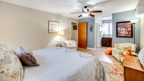 A bedroom with a bed, a chair, a desk, a ceiling fan, and a door leading to a bathroom. - Rector Home w/ Hot Tub ~ 6 Mi to Ligonier! (Ligonier)