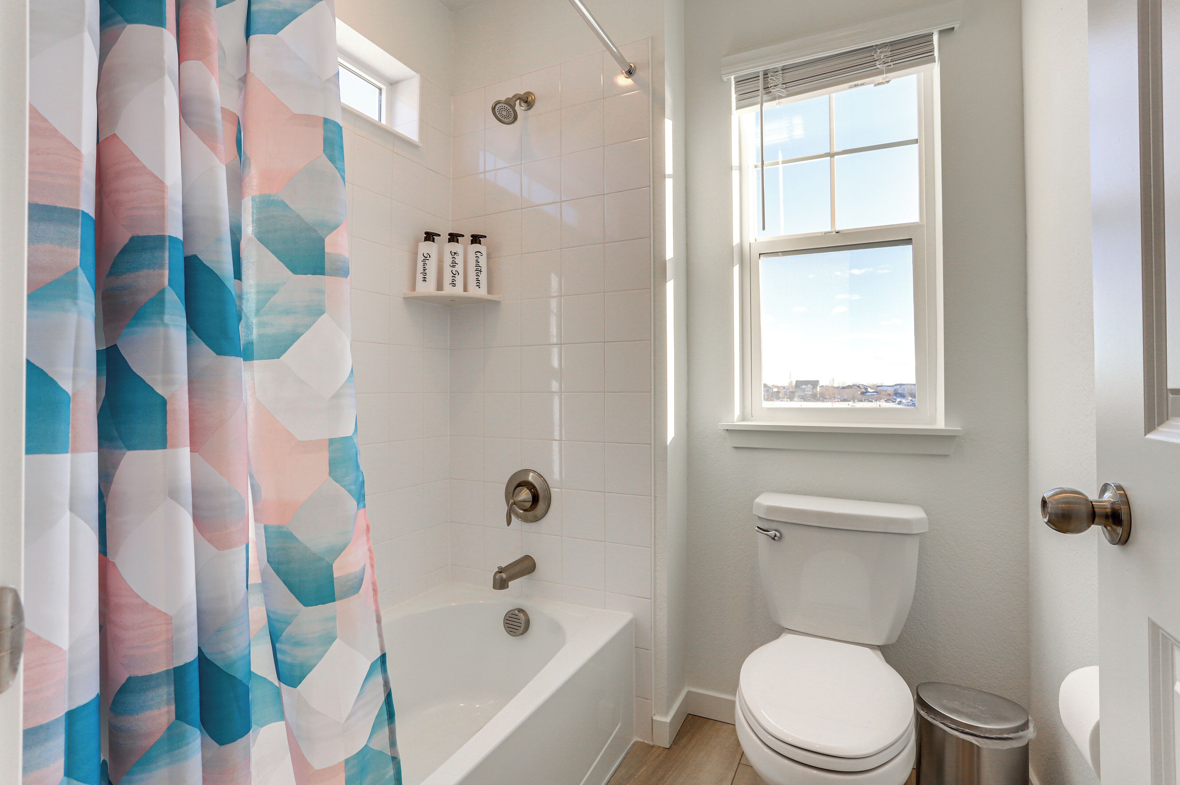 A bathroom with a bathtub, toilet, and shower curtain.