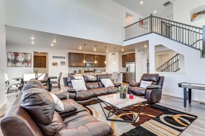 A spacious living room with a sectional sofa, a coffee table, and a pool table. - 16 Mi to Denver: Spacious Commerce City Home! (Commerce City)