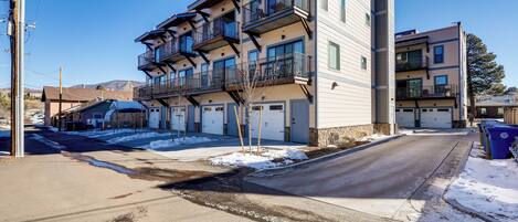A multi-story residential building with balconies, a garage, and a clear sky.