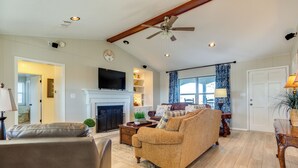 A spacious living room with a fireplace, a television, and a ceiling fan. - On-site Lake Access + Fire Pit: Bonham Home! (Bonham)