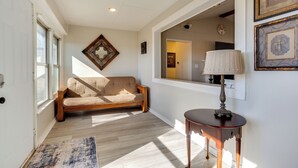 A hallway with a wooden floor, a beige sofa, a round table with a lamp, and framed artwork on the wall. - On-site Lake Access + Fire Pit: Bonham Home! (Bonham)