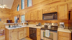 A wooden cabin-style kitchen with a built-in microwave, stove, oven, and sink. - Peaceful Ellijay Cabin: Pool Access & Resort Perks (Ellijay)