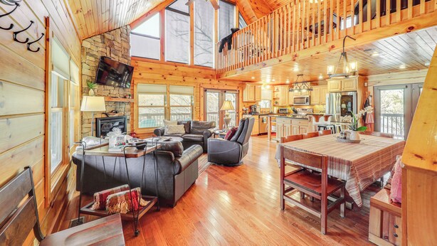 A spacious cabin with a loft bedroom, a dining area, a kitchen, and a living room with a fireplace. - Waterfront Watauga Lake Home w/ Private Dock! (Butler)