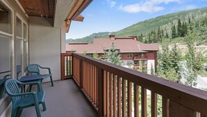 A balcony with wooden railings, a view of a mountain, and a building with a red roof. - 3506 - One Bedroom + Den Standard Powderhorn Lodge 1 Condo by RedAwning (Salt Lake City)