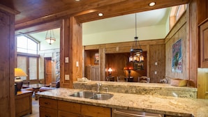 A kitchen with wooden cabinets, granite countertops, stainless steel sink, and a dishwasher.