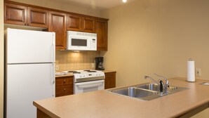 A kitchen with wooden cabinets, a white refrigerator, a microwave, a stove, and a sink. - 3212 - One Bedroom Standard Powderhorn Lodge 1 Condo by RedAwning (Salt Lake City)