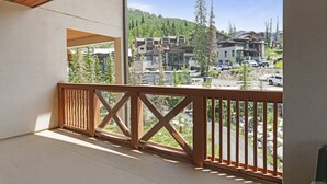 Ein Balkon mit Holzgeländer mit Blick auf eine Wohngegend mit Häusern und Bäumen.