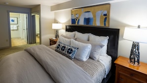 A bedroom with a large bed, a headboard, two bedside tables, and a painting on the wall. - 2214 - Two Bedroom Standard Eagle Springs East 2 Condo by RedAwning (Solitude)