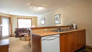 A kitchen with a dishwasher, wooden cabinets, a sink, and a window. - 3316 - One Bedroom + Den Standard Powderhorn Lodge 1 Condo by RedAwning (Salt Lake City)