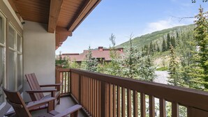 A balcony with wooden chairs and a view of a forested mountain. - 3406 - One Bedroom + Den Standard Powderhorn Lodge 1 Condo by RedAwning (Salt Lake City)