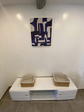 Bathroom features a white vanity with sink and storage, paired with a large abstract artwork.