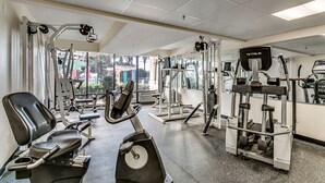 A gym with various exercise equipment, including treadmills, weight machines, and a rowing machine.