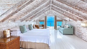 A spacious attic bedroom with a large bed, a sofa, and a view of the ocean. - Easy Reach by Blue Sky Luxury (Mullins)