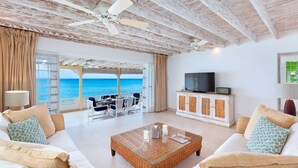 A room with a view of the sea, a television, and a dining area. - Easy Reach by Blue Sky Luxury (Mullins)