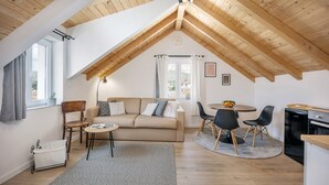A cozy loft-style room with a high wooden ceiling, a beige sofa, a dining table with chairs, and a kitchen area. - Rooftop Studio apartment Yucca for 2+2, 2-min to the beach and 5 to Trogir (Trogir)
