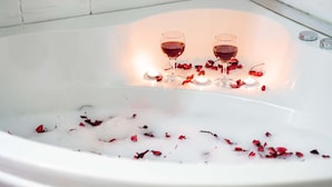 A bathtub with rose petals and two glasses of red wine. - Gama Residence (Izmir)