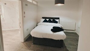 A bedroom with a bed, a radiator, and a ceiling light. - Stunning 3-bed House in Oldbury (Oldbury)
