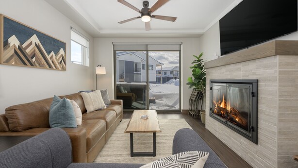 Una sala de estar moderna con chimenea, sofá de cuero y televisor de pantalla plana.