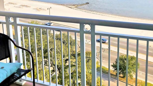 Un balcon avec vue sur la mer et une route.