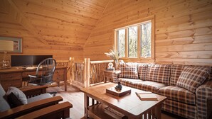 A cozy cabin interior with a wooden ceiling, a sofa, a desk, and a window. - Outstanding Views! 5BR/4.5 BA/ Sleeps 14, Hot-Tub, Pool Table! (Maggie Valley)