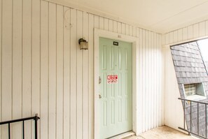 A light green door with a "NO SMOKING" sign, a small window, and a metal railing. - A bedroom in close proximity to Fort Sill! (Lawton)
