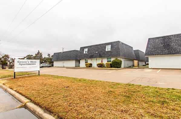 A row of single-story, two-story apartment buildings with a sign indicating 'Green's West Apartments'. - A bedroom in close proximity to Fort Sill! (Lawton)