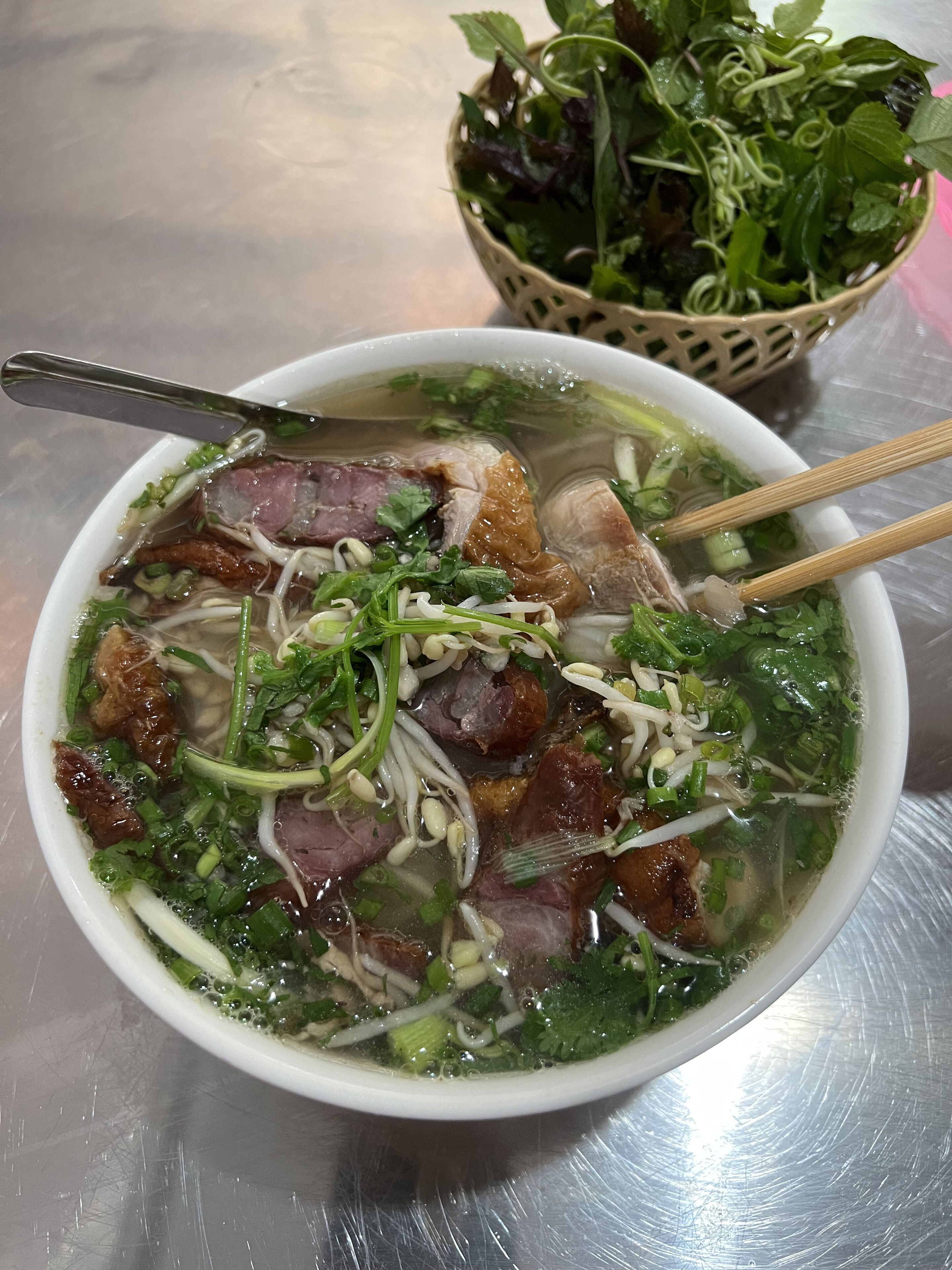 A bowl of soup with noodles, meat, and vegetables.