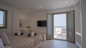 A modern bedroom with a large bed, a TV, and a balcony with a view. - Paros Breeze Luxury Villa (Paros)