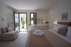 Ein modernes Schlafzimmer mit einem großen Bett, einer Sitzecke und einem Schreibtisch.