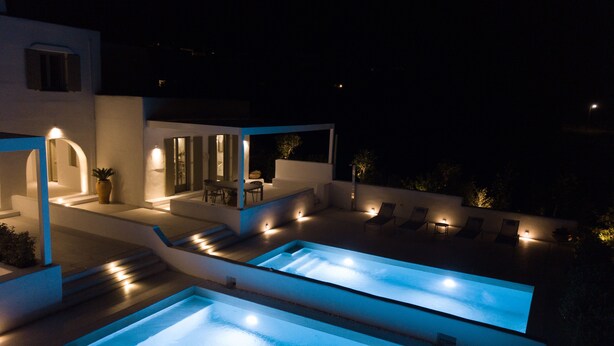 A modern outdoor pool area with built-in seating and ambient lighting. - Paros Breeze Luxury Villa (Paros)