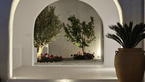 A modern interior with a white arched window overlooking a garden. - Paros Breeze Luxury Villa (Paros)