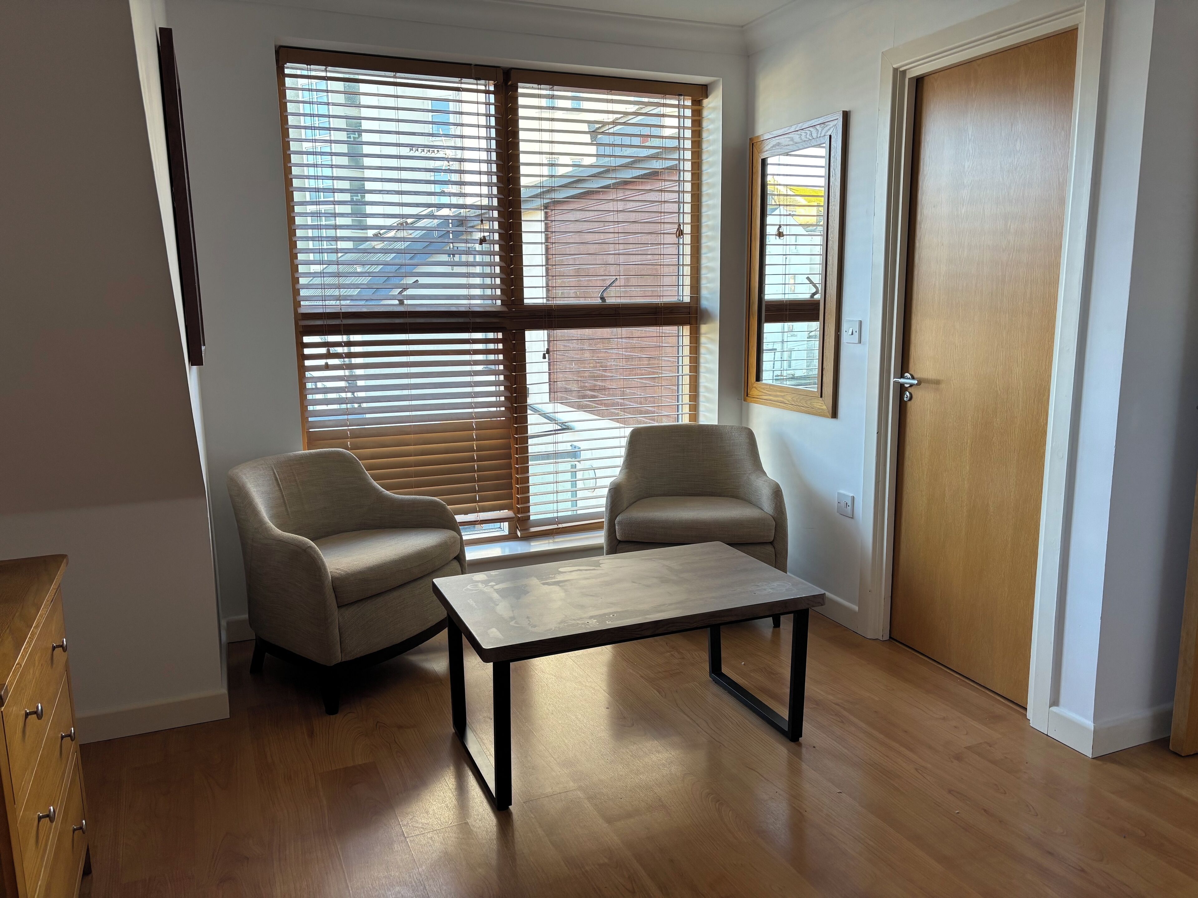 A room with two chairs, a table, and a door.