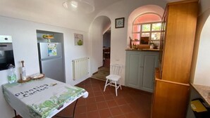 Une cuisine compacte comprenant une table à manger, un réfrigérateur et un meuble en bois.