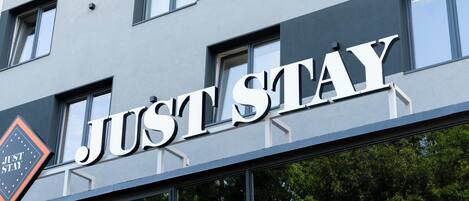 A building with a sign that reads "JUST STAY".