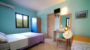 Une chambre avec deux lits, un bureau, une chaise, un miroir et une fenêtre.