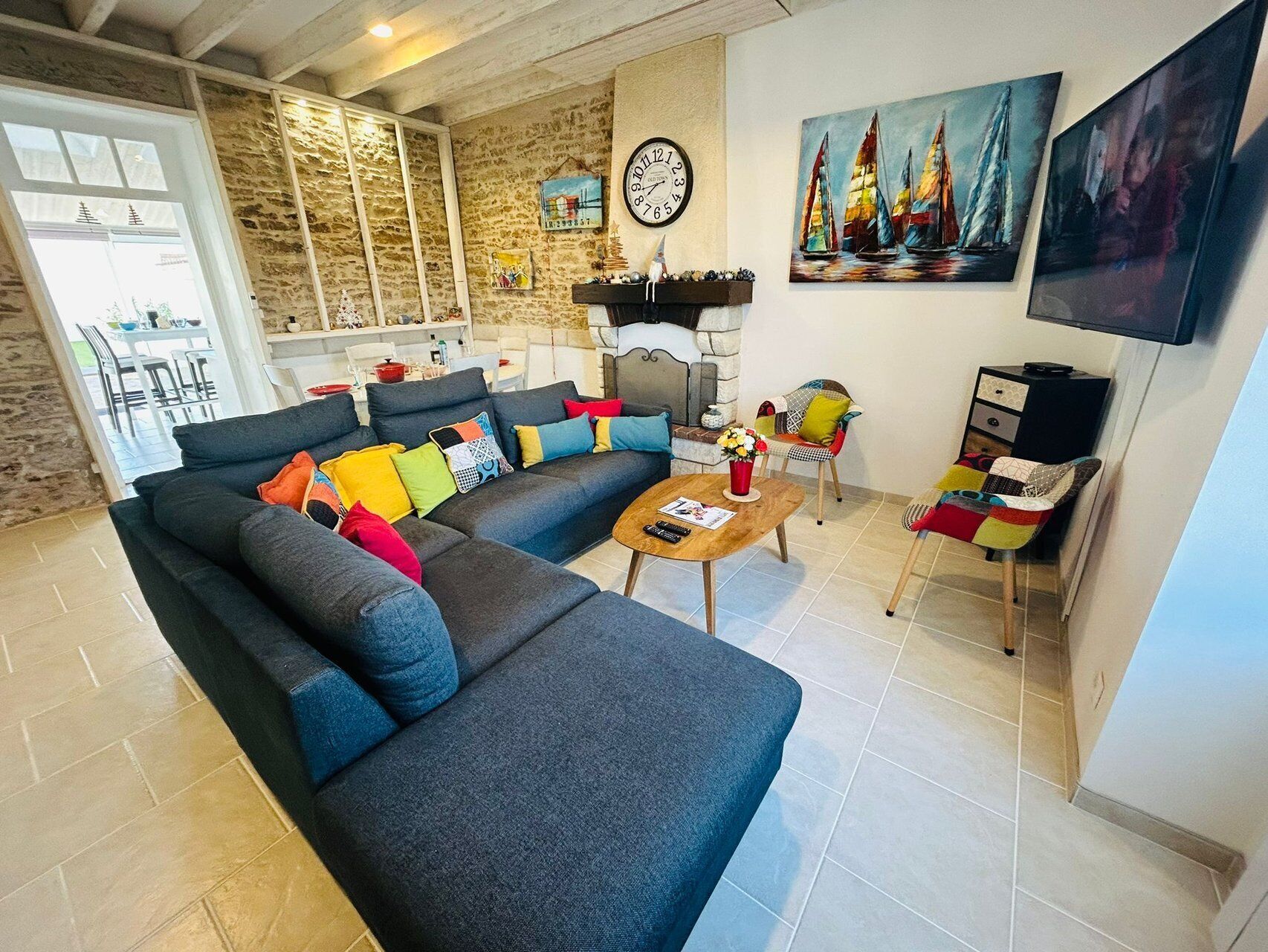 Ein Wohnzimmer mit einer Couch, einem Couchtisch, einem Kamin und einem Gemälde von Segelbooten.